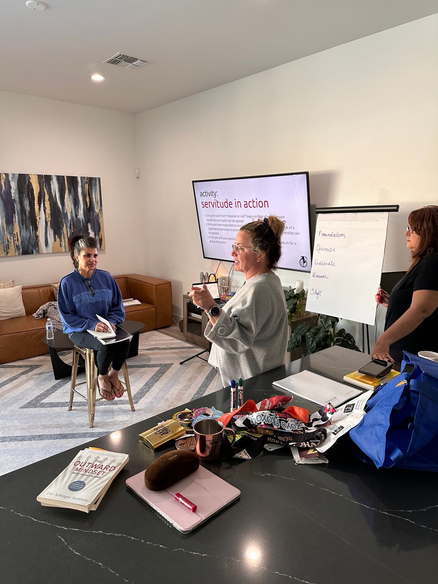 Women engaging in a group activity with notes and presentation in a cozy living room setting.