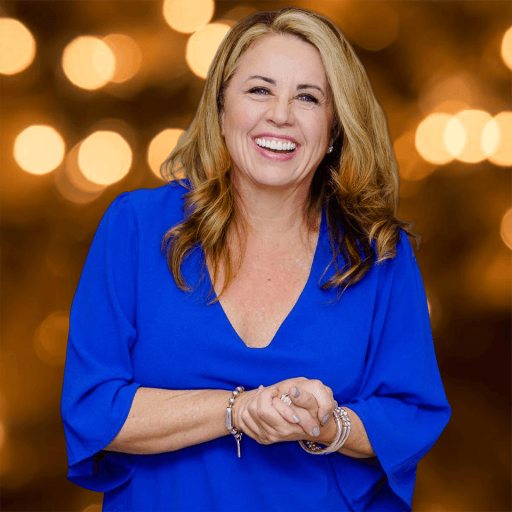 Woman in a blue dress smiling with bokeh lights in the background.